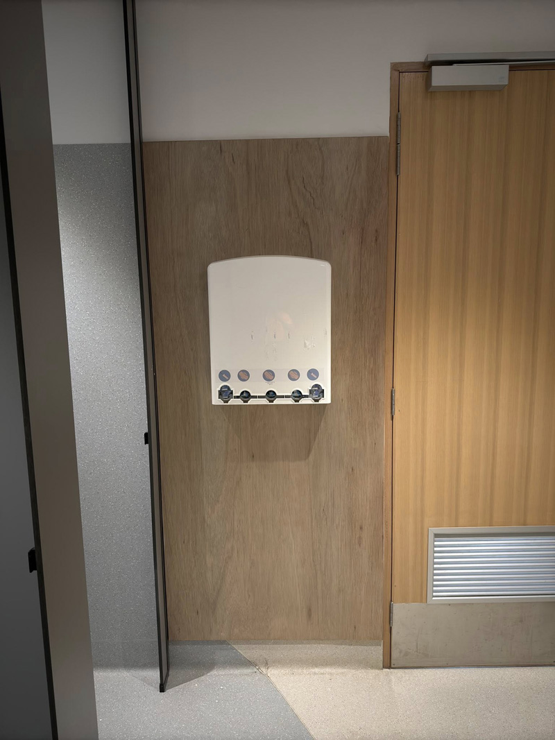 Timber-look wall panel with a white hook rack beside a timber door