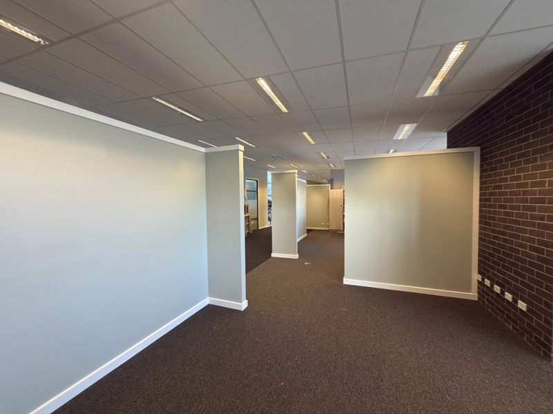 Office area with newly painted partition walls beside a brick wall