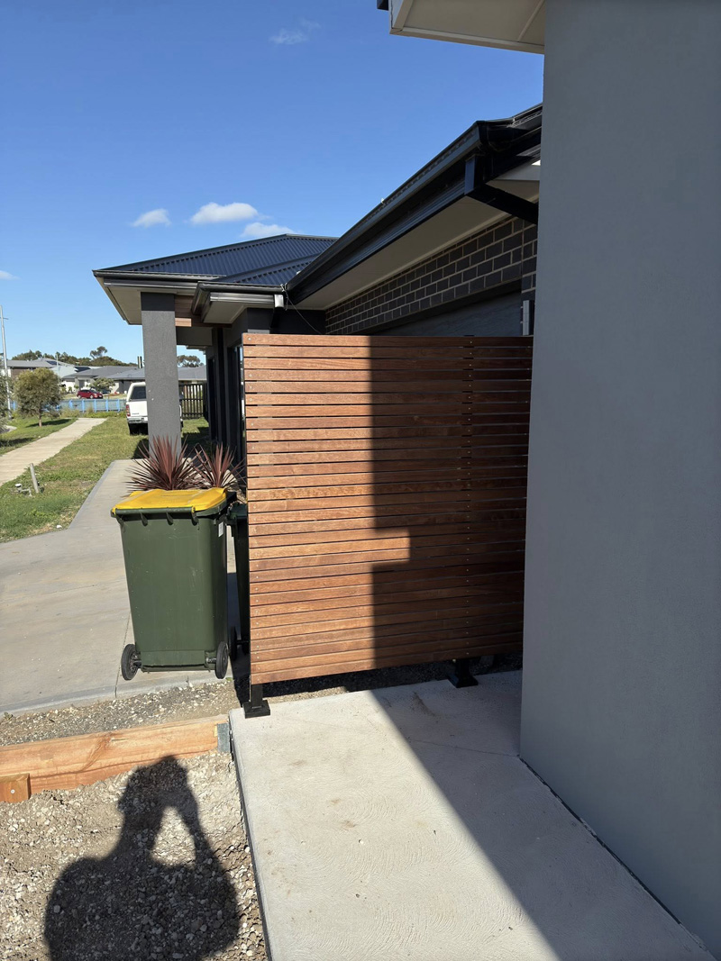 Horizontal timber slat side gate between a house and a fence